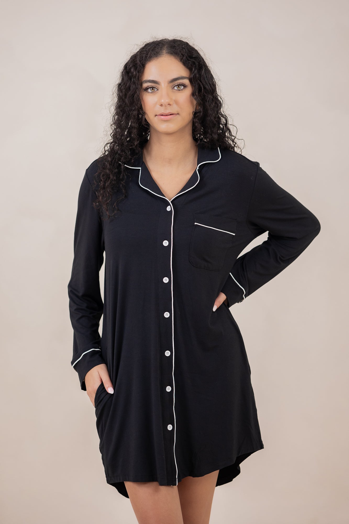 Woman with hand on hip modeling the Kyte Sleep Shirt in Midnight