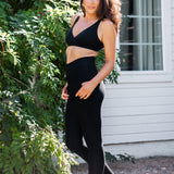 Female model posing wearing the Bamboo Flex Women’s Leggings in Midnight and matching cross front bralette