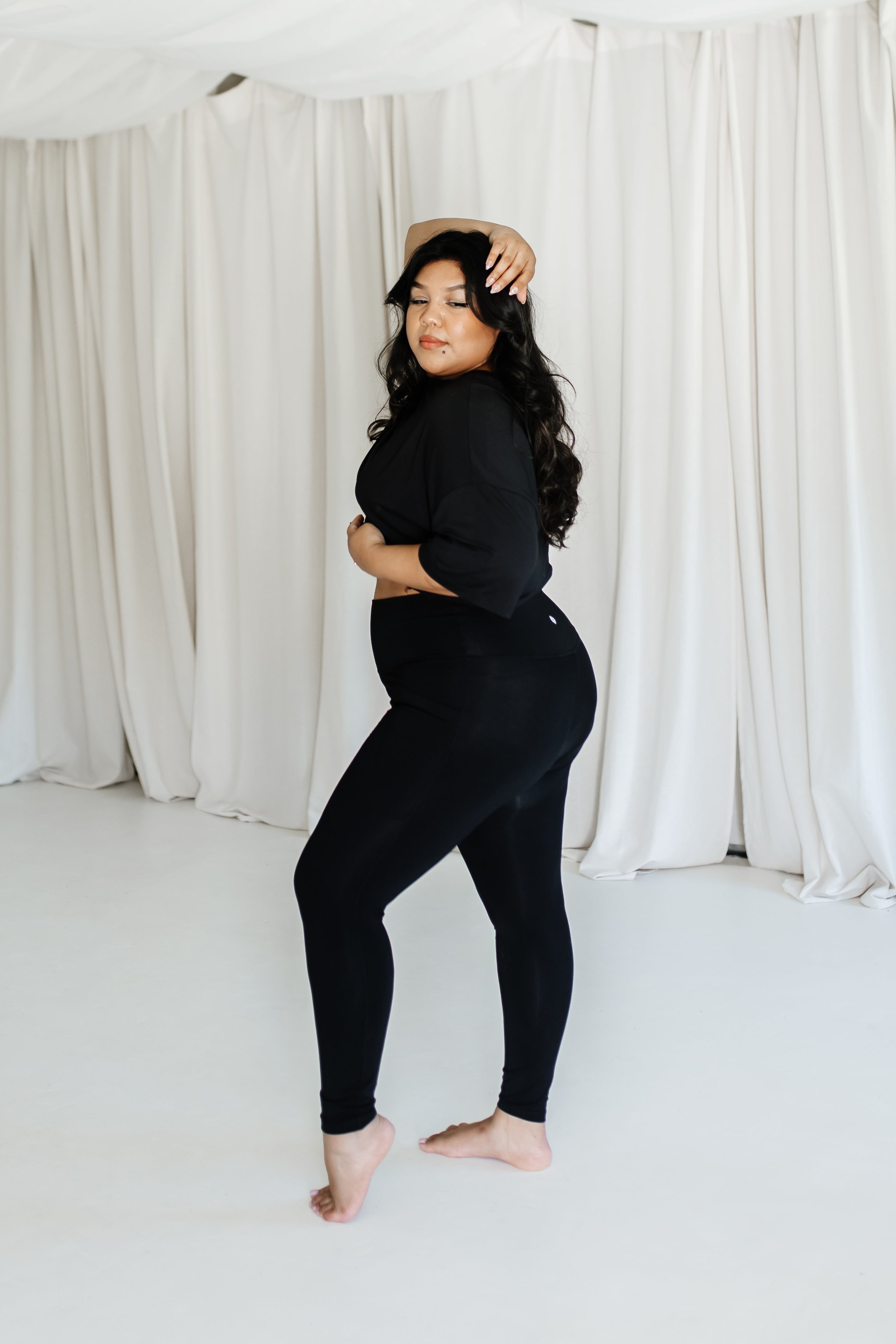 Female model posing wearing the Bamboo Flex Women’s Leggings in Midnight and matching short sleeve tee