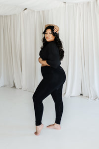 Female model posing wearing the Bamboo Flex Women’s Leggings in Midnight and matching short sleeve tee