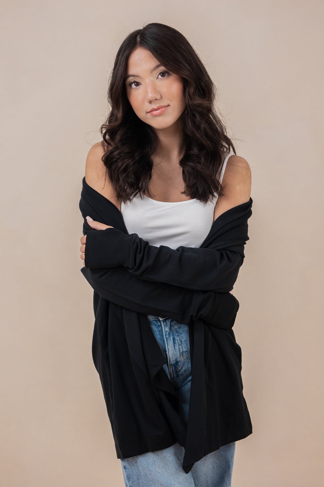 Woman wearing the Kyte Women's French Terry Wrap Top in Midnight off of her shoulders paired with a cami in cloud 