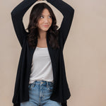 Smiling model with arms over her head wearing the Women's French Terry Wrap Top in Midnight