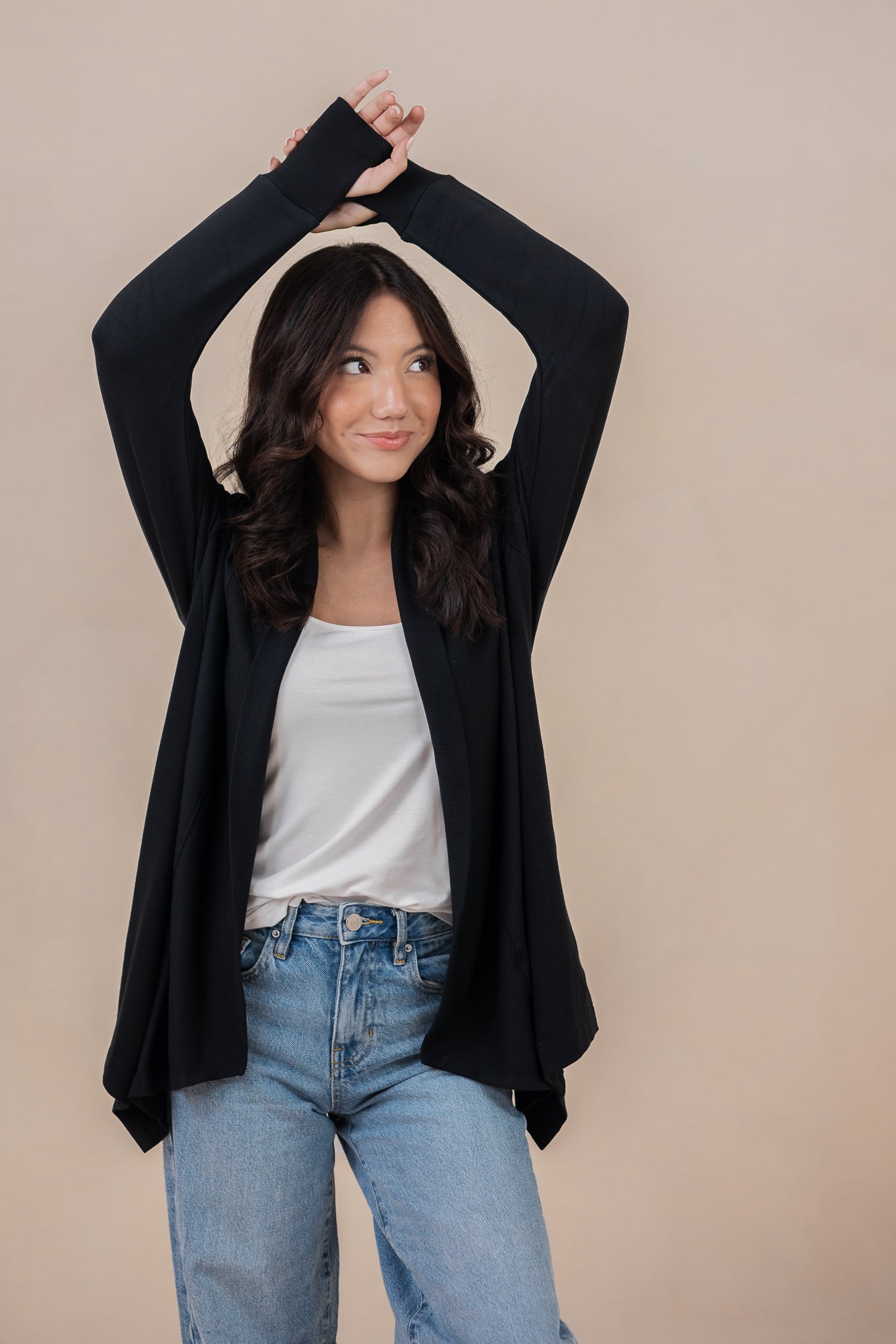 Smiling model with arms over her head wearing the Women's French Terry Wrap Top in Midnight