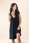 Woman wearing a black nightgown against a beige background