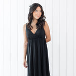 Woman wearing a black nightgown dress against a white background