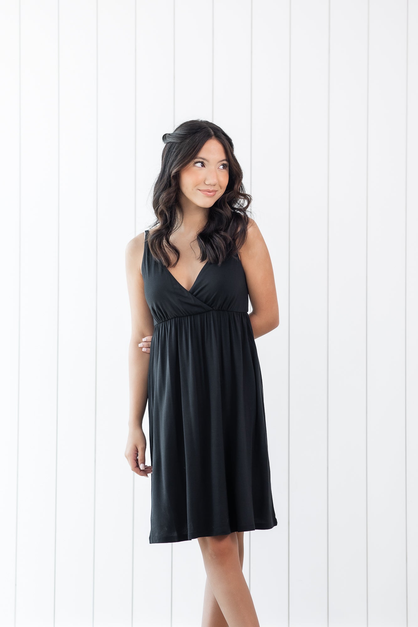 Woman wearing a black nightgown dress against a white background