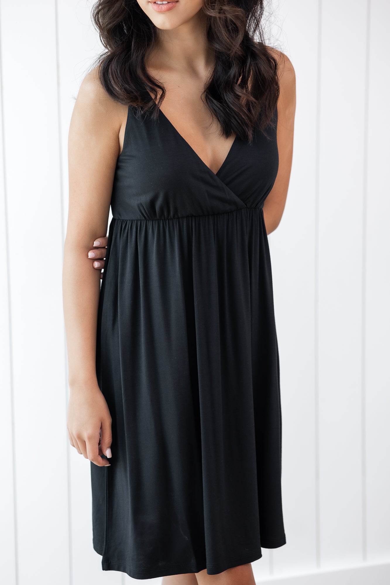 Woman wearing a black nightgown against a white background