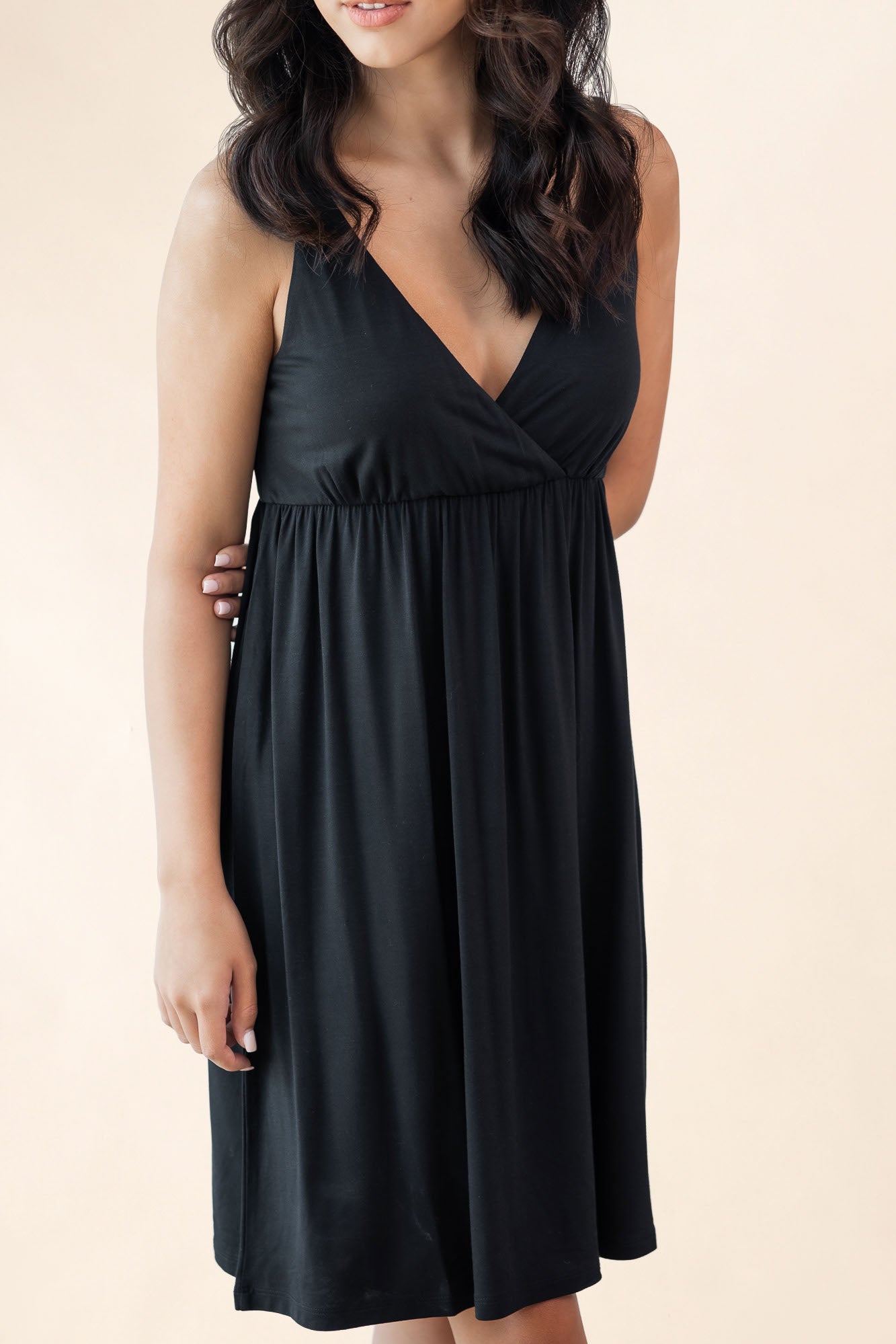 Woman wearing a black nightgown on a beige background