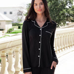 Woman soft smiling outside with her hand in her pocket wearing a long sleeve pajama set in midnight with cloud trim.
::: Model is 5'10.5" wearing size S ///
---PJ 2