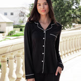 Woman soft smiling outside with her hand in her pocket wearing a long sleeve pajama set in midnight with cloud trim.
::: Model is 5'10.5" wearing size S ///
---PJ 2