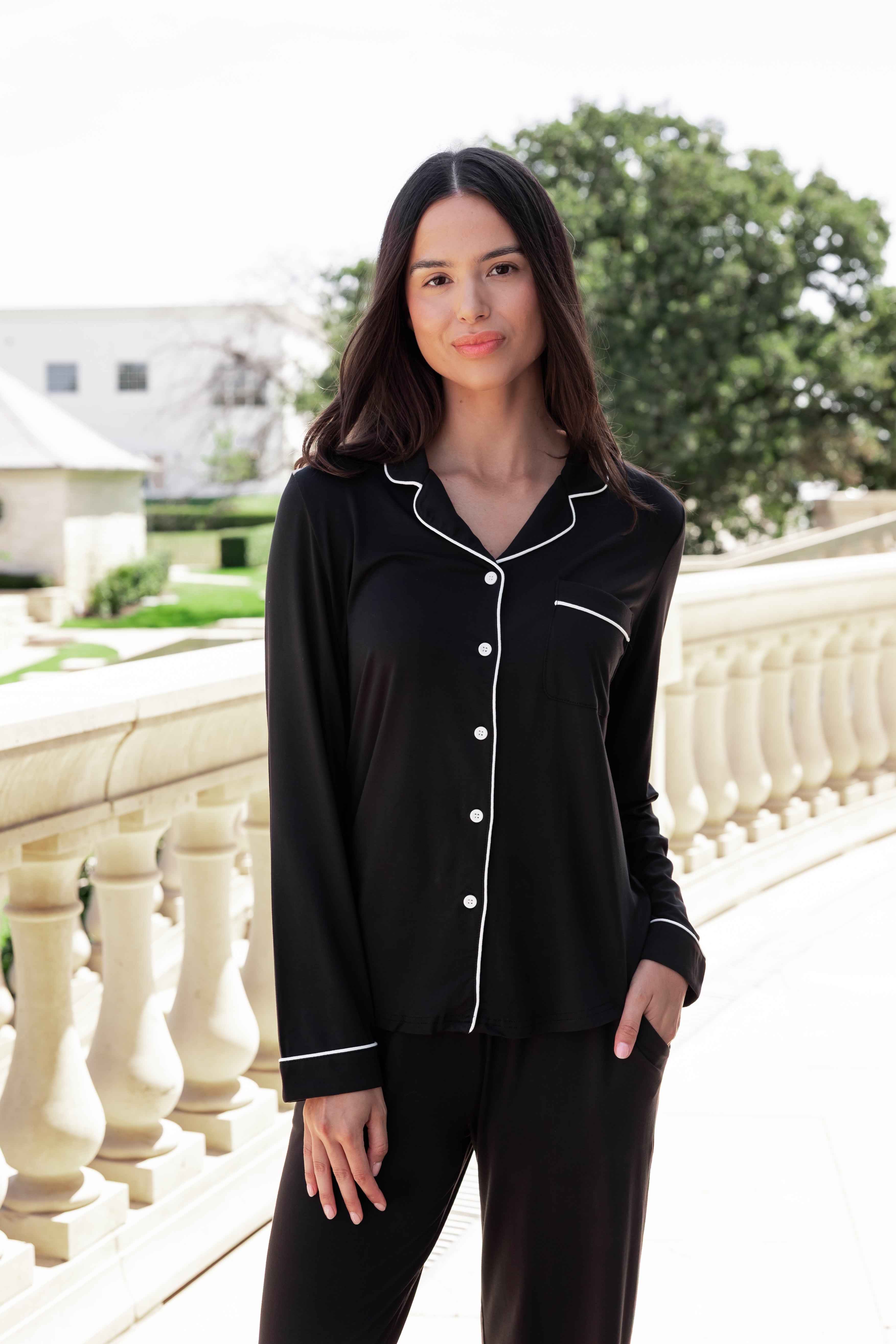 Woman soft smiling outside with her hand in her pocket wearing a long sleeve pajama set in midnight with cloud trim.
::: Model is 5'10.5" wearing size S ///
---PJ 2