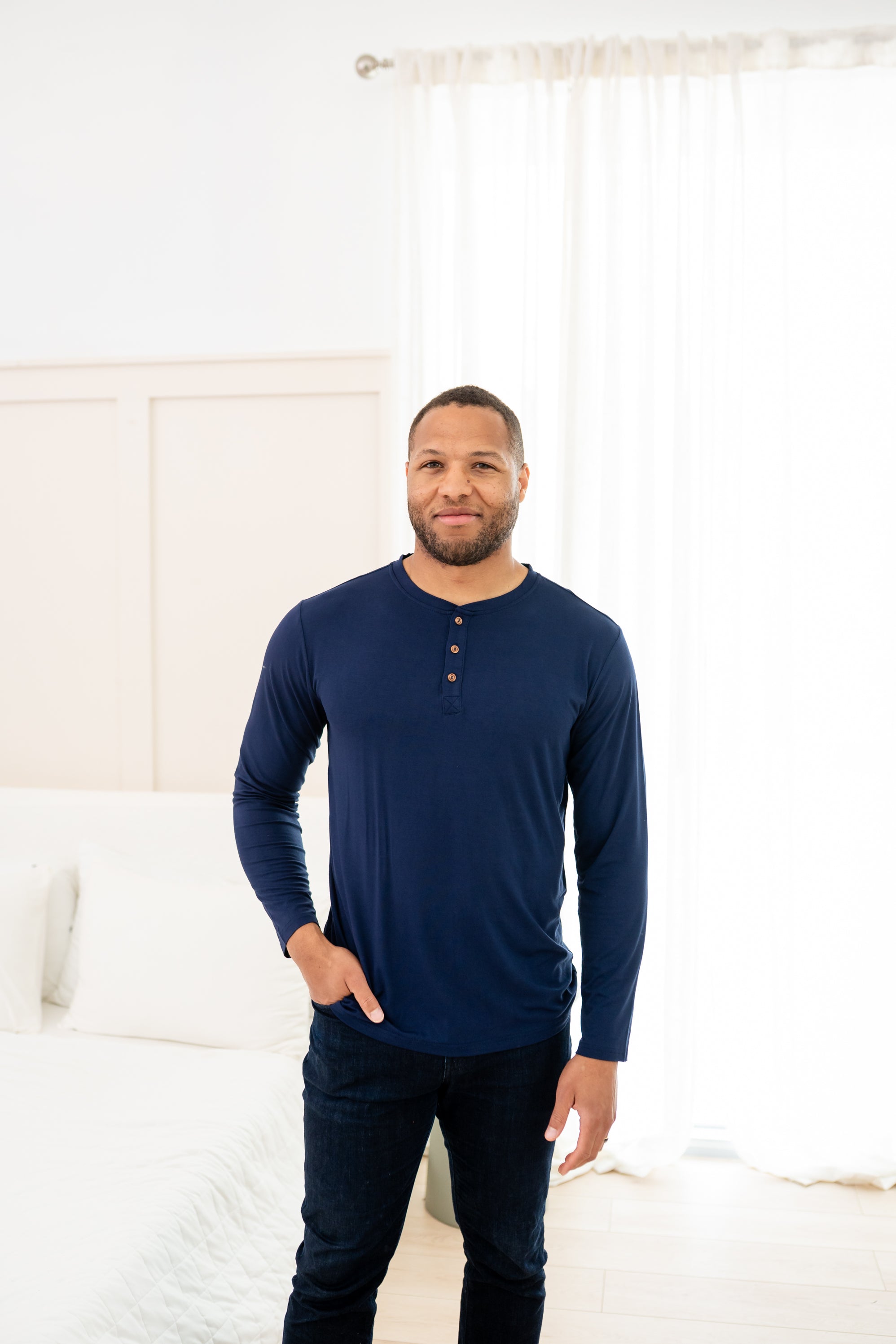 Man modeling Men's Long Sleeve Henley Top in Navy with jeans with hand in pocket