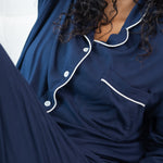 Woman modeling long sleeve button up navy pajamas 