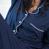 Woman modeling long sleeve button up navy pajamas 