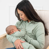 Woman breastfeeding infant while wearing the Women's French Terry Nursing Hoodie in Thyme