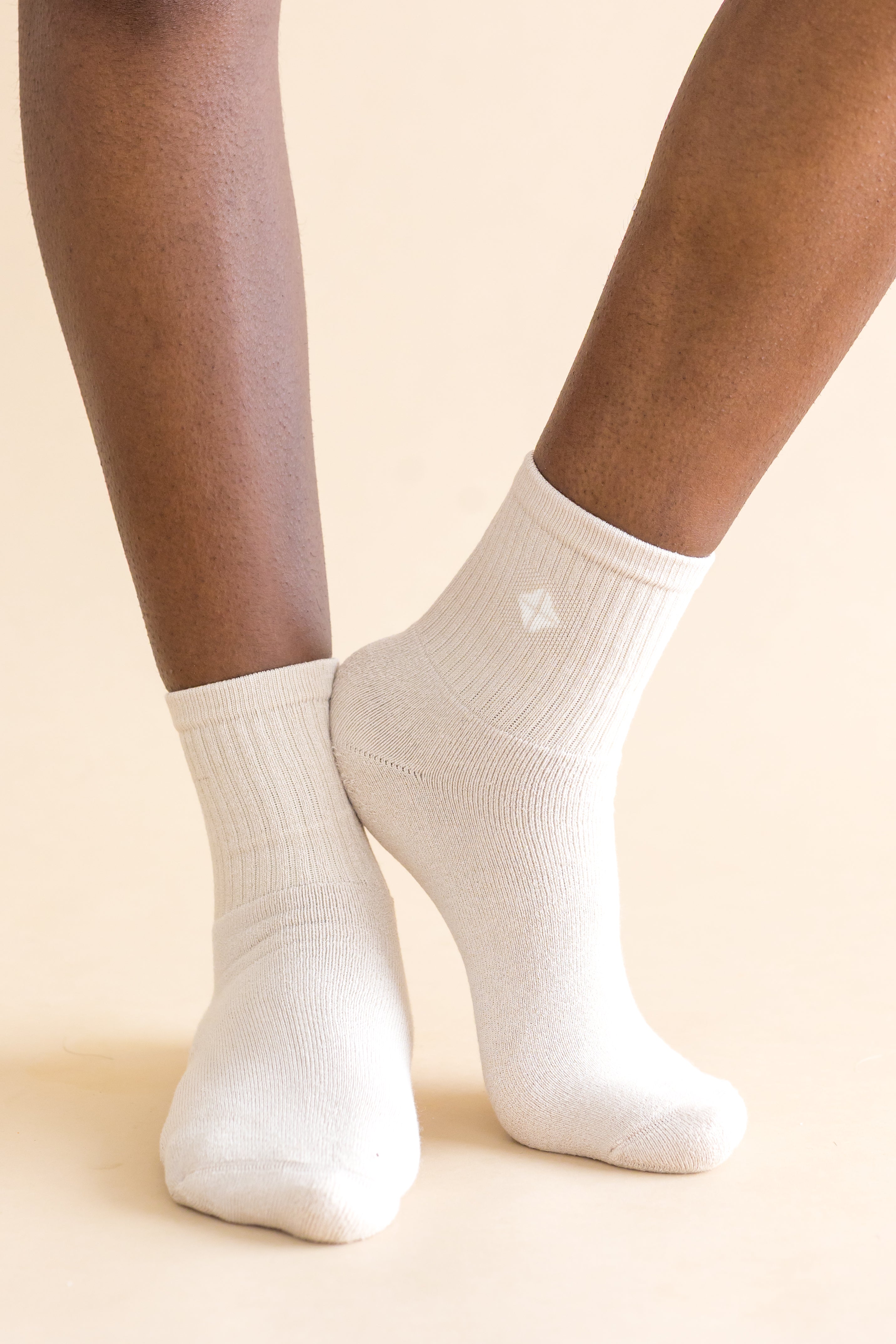 cream socks worn by a person on a beige background