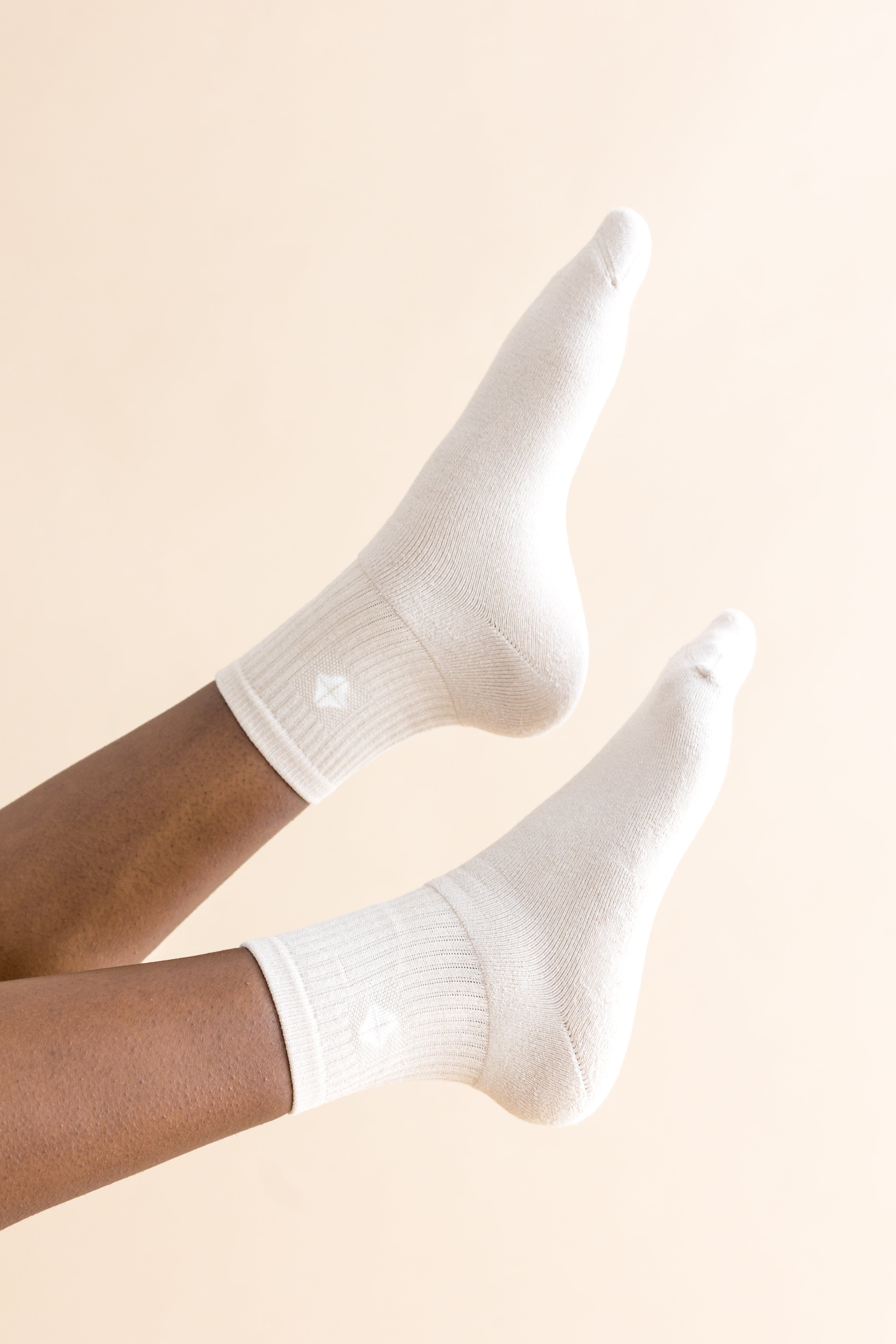 cream socks worn by a person on a beige background