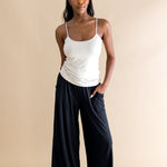 Woman wearing a beige tank top and black wide-leg pants on a beige background ::: Model is 5'9" wearing size S ///