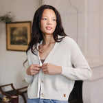 Woman looking over her shoulder buttoning her cropped cardigan in oat
::: Model is 5'10" wearing size S ///