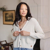 Woman looking over her shoulder buttoning her cropped cardigan in oat
::: Model is 5'10" wearing size S ///