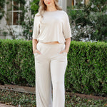woman modeling a creamy off white wide leg pant and cropped tee in an outdoor setting
