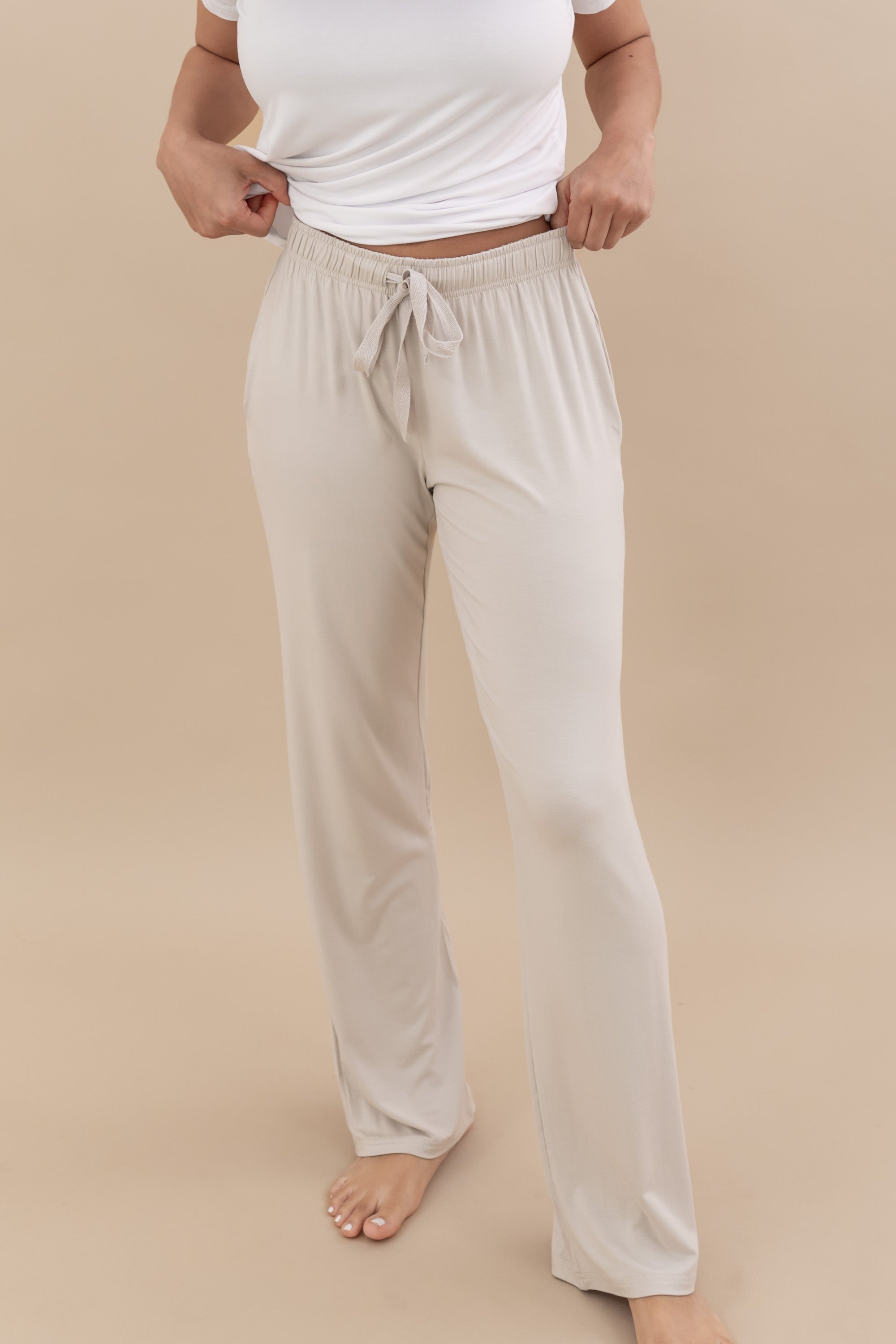 Model wearing the Women's Lounge Pants in Oat paired with a white shirt