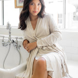 Woman in a off white robe sitting by a window with a sink in the background ::: Model is 5'2" wearing size XS/S ///