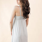 Woman wearing a light gray nightgown against a beige background