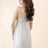 Woman wearing a light gray nightgown against a beige background