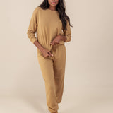 Modal wearing Women's Jogger Pants in Ochre color under similar color women's sweatshirt on a beige background
