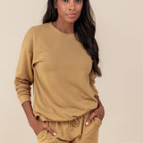 Woman oft smiling with her hands in her sweatpants pockets wearing a sweatshirt in ochre
::: Model is 5'9" wearing size M ///
