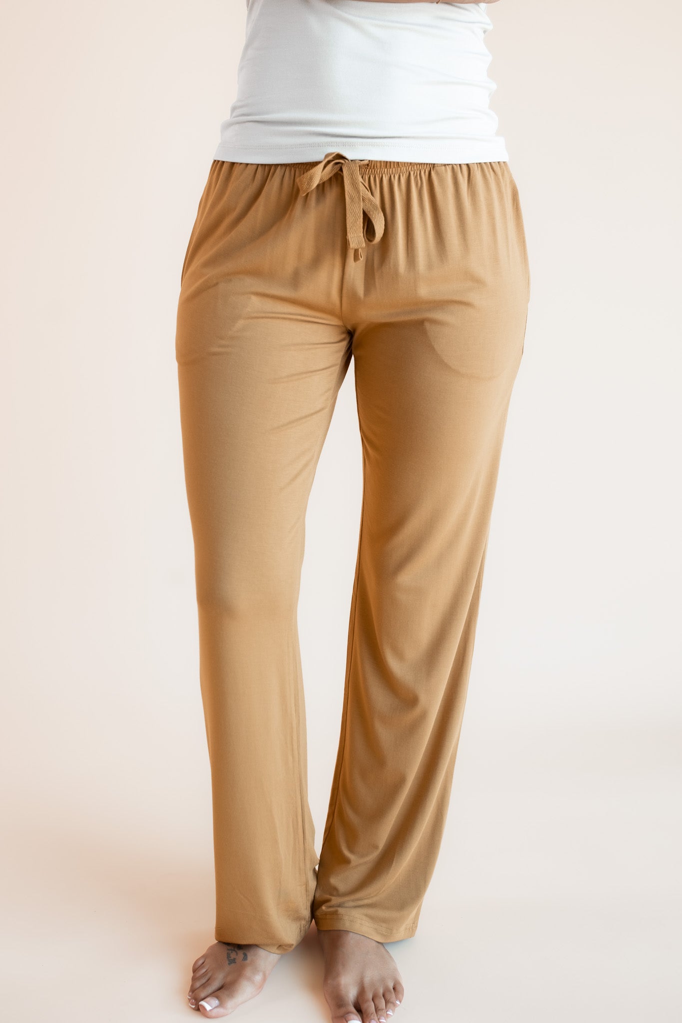 Model wearing Women's Lounge Pants in Ochre under white camisole on a beige background
::: Model is 5'9"" wearing size S ///
