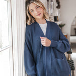 Woman leaning up against the wall wearing an oversized cardigan in oxford
::: Model is 5'10" wearing size XS ///