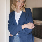 Modal standing against a wall wearing Chunky Knit Women's Waffle Cardigan in Oxford over white t-shirt and blue jeans
::: Model is 5'10" wearing size XS ///
