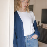 Modal posing wearing Chunky Knit Women's Waffle Cardigan in Oxford over white t-shirt and blue jeans
