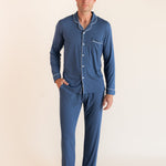 Male model wearing oxford blue button up long sleeve pajamas in a studio setting