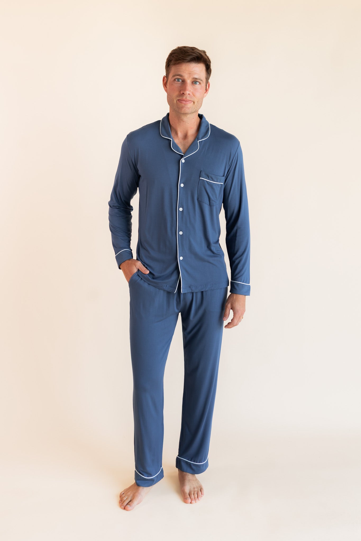 Male model wearing oxford blue button up long sleeve pajamas in a studio setting
::: Model is 6'2" wearing size M ///