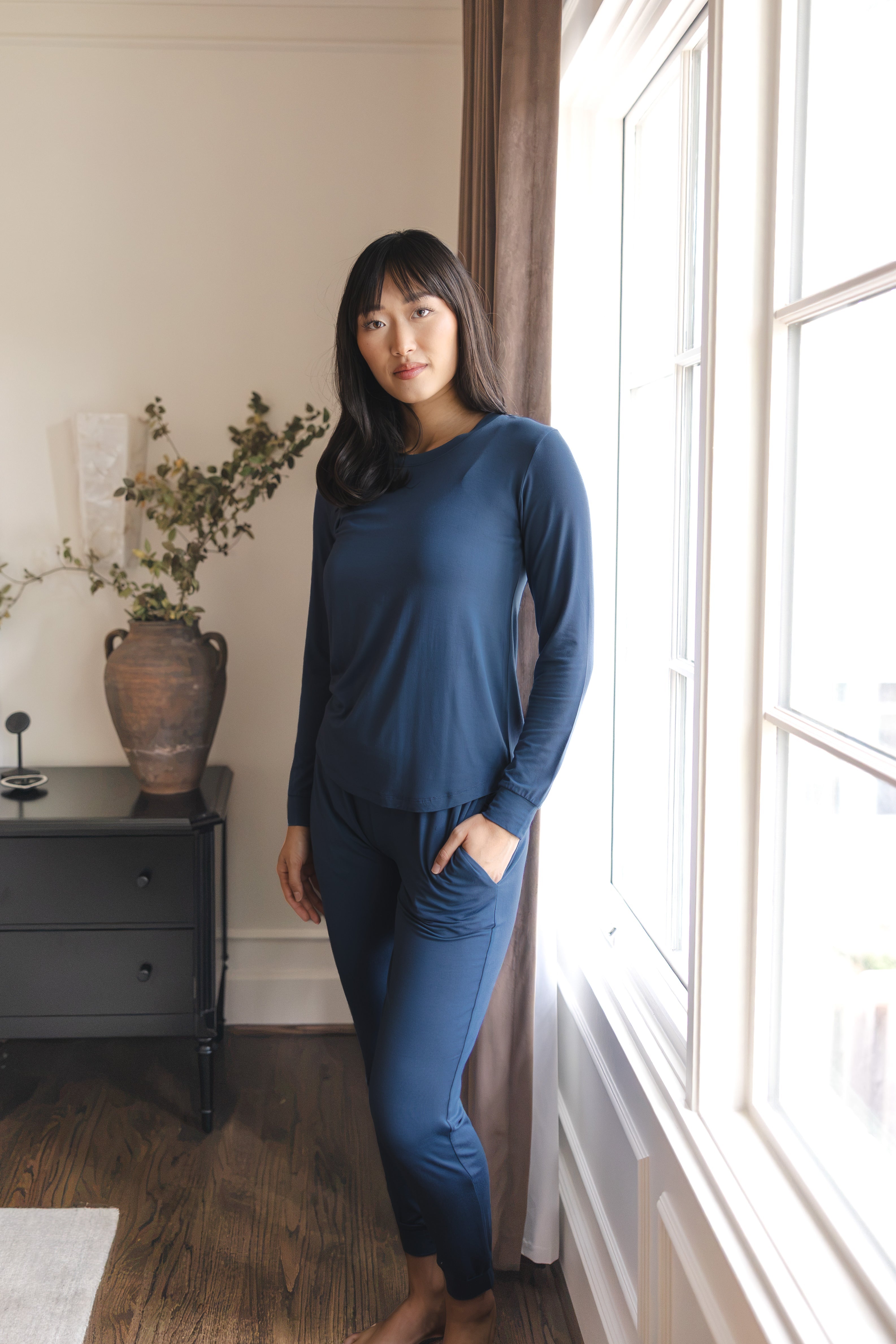Modal wearing Women's Jogger Pajama Set in Oxford standing near a glass window
::: Model is 5'9" wearing size S ///