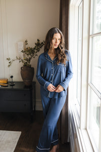 Modal wearing Long-Sleeved Women's Pajama Set in Oxford standing against a large window