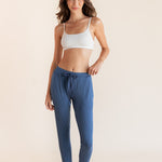 Model wearing oxford blue jogger pant with drawstring waist and neutral bralette