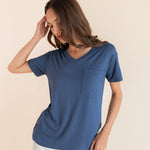 Woman modeling a oxford blue v-neck oversized tee with white jeans