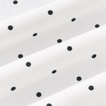 Close up view of Midnight polka dot print on white fabric