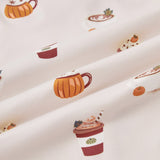 A repeating, all-over print featuring: a white cappuccino cup with latte art and a green leaf garnish, next to a mini pumpkin and a dusting of cocoa powder; an orange pumpkin-shaped mug with whipped cream and garnished with star anise and a cinnamon stick; a rust-colored to-go coffee cup with orange whipped cream, a dark green leaf, and a straw; and a yellow mug with a maple leaf image, topped with whipped cream, cloves, and a mini orange pumpkin, over a light beige background color named Vanilla.