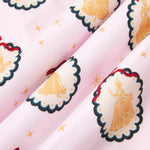 An all-over print featuring rows of scalloped medallions with a dark green border, gold dots, and a thin red bow at the top, over a pale pink background color called Sakura. One row of medallions alternates gold silhouettes of Cinderella holding her glass slipper, and Snow White with a bird on her finger. Another row of medallions alternates gold silhouettes of Belle holding her skirt and a rose, and Tiana holding her skirt.
---1605 1