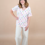 Woman standing with hand on hip while modeling the Women's V Neck in Pastel Ghost paired with Khaki pants