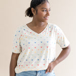 Woman smiling to the side while modeling the Women's Relaxed Fit V-Neck in Pastel Mickey Mouse paired with light wash denim
::: Model is 5'1" wearing size S ///