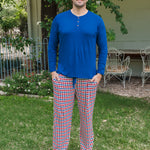 Man wearing Kyte Men's Long Sleeve Henley Top in Tahoe over red white and blue print Men's lounge pant outdoors