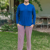 Man wearing Kyte Men's Long Sleeve Henley Top in Tahoe over red white and blue print Men's lounge pant outdoors