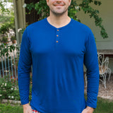Smiling man modeling the Kyte Men's Long Sleeve Henley Top in Tahoe with red white and blue print Men's lounge pant outdoors