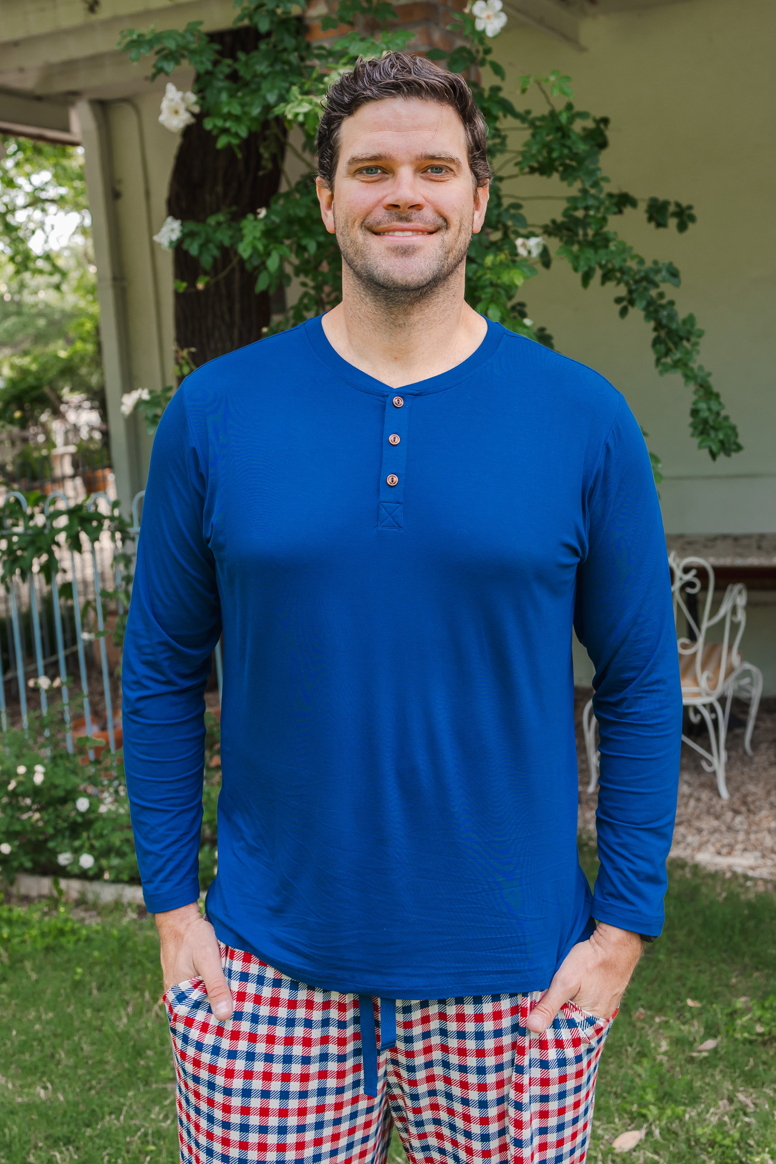 Smiling man modeling the Kyte Men's Long Sleeve Henley Top in Tahoe with red white and blue print Men's lounge pant outdoors